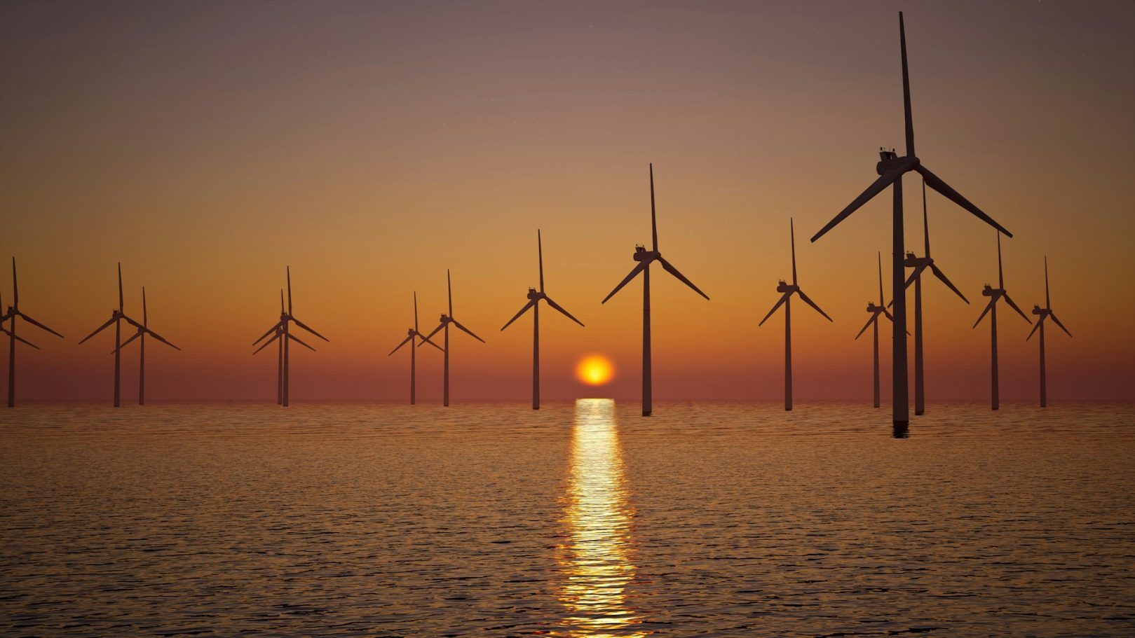Wind turbines on the water at sunset, reflecting light across the waves.