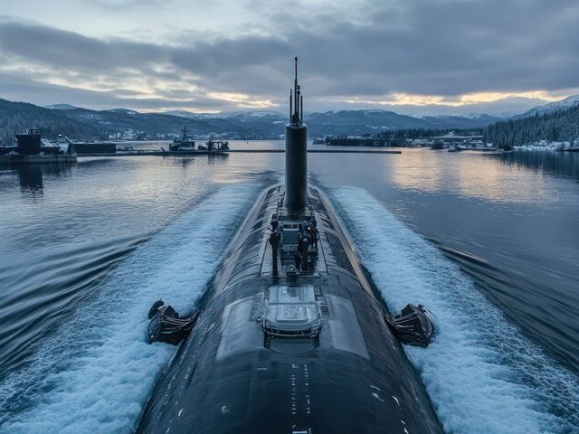A submarine navigating through calm waters with mountains in the background.